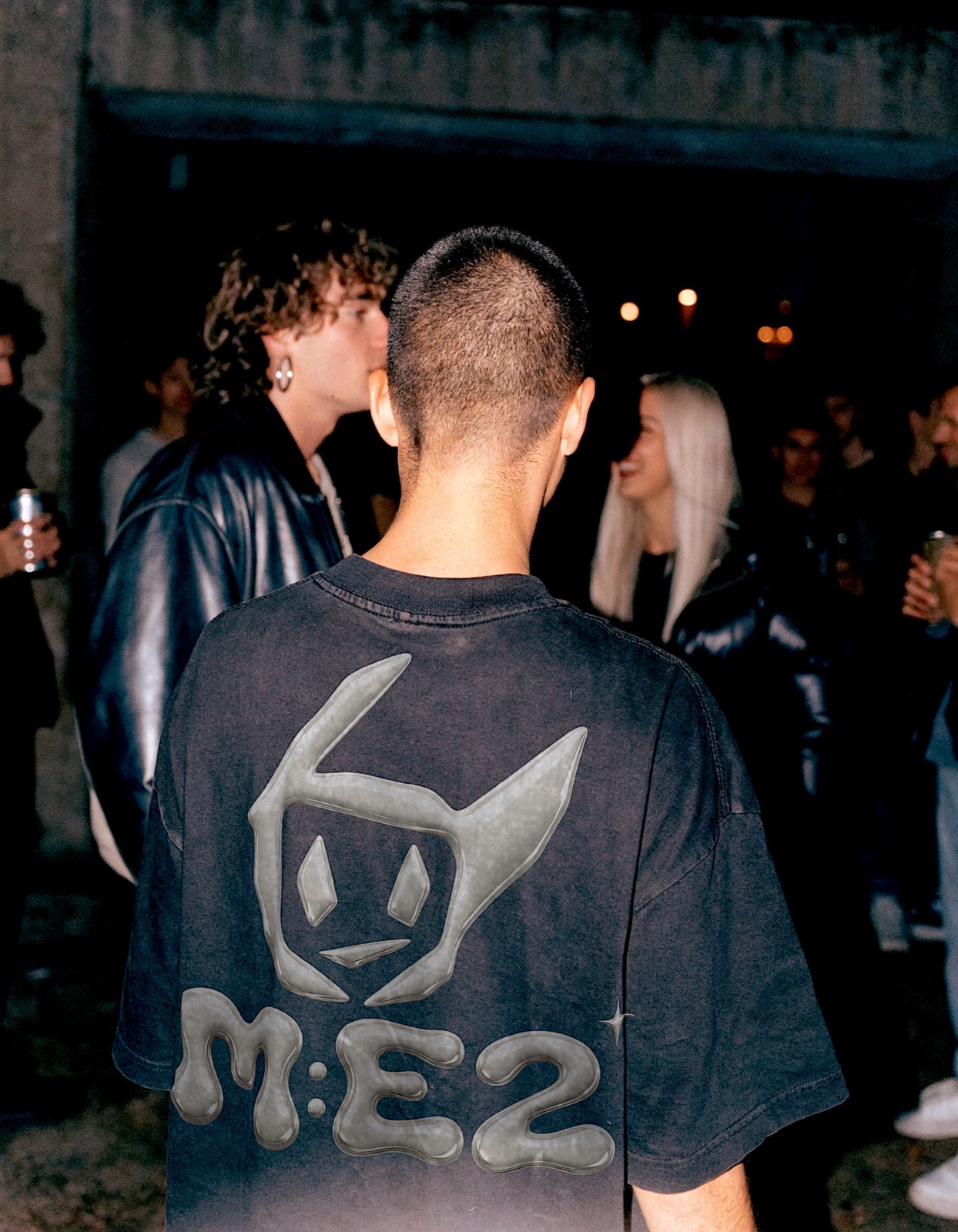M:E2 back logo in a social crowd